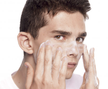 Joven lavándose el rostro con jabón bioderma