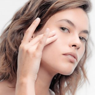 Mujer aplicando se crema facial Mujer aplicando se crema facial