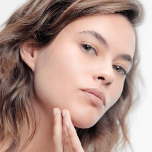 Mujer aplicando se crema facial bioderma